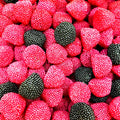 Snoepbramen en frambozen met korrelstructuur in roze, rood en zwart