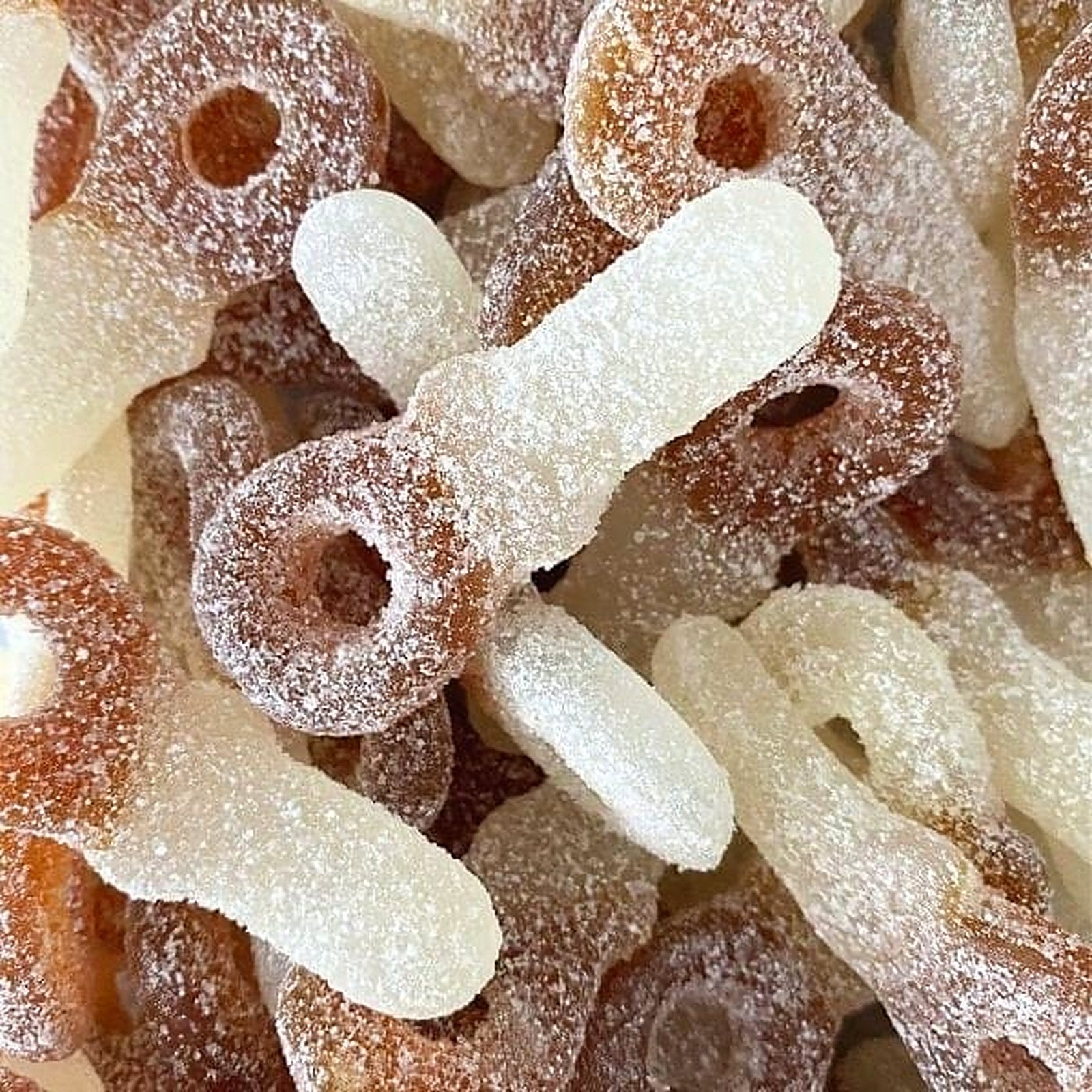 Zure cola spenen in crème en cola-bruin met zuurzand